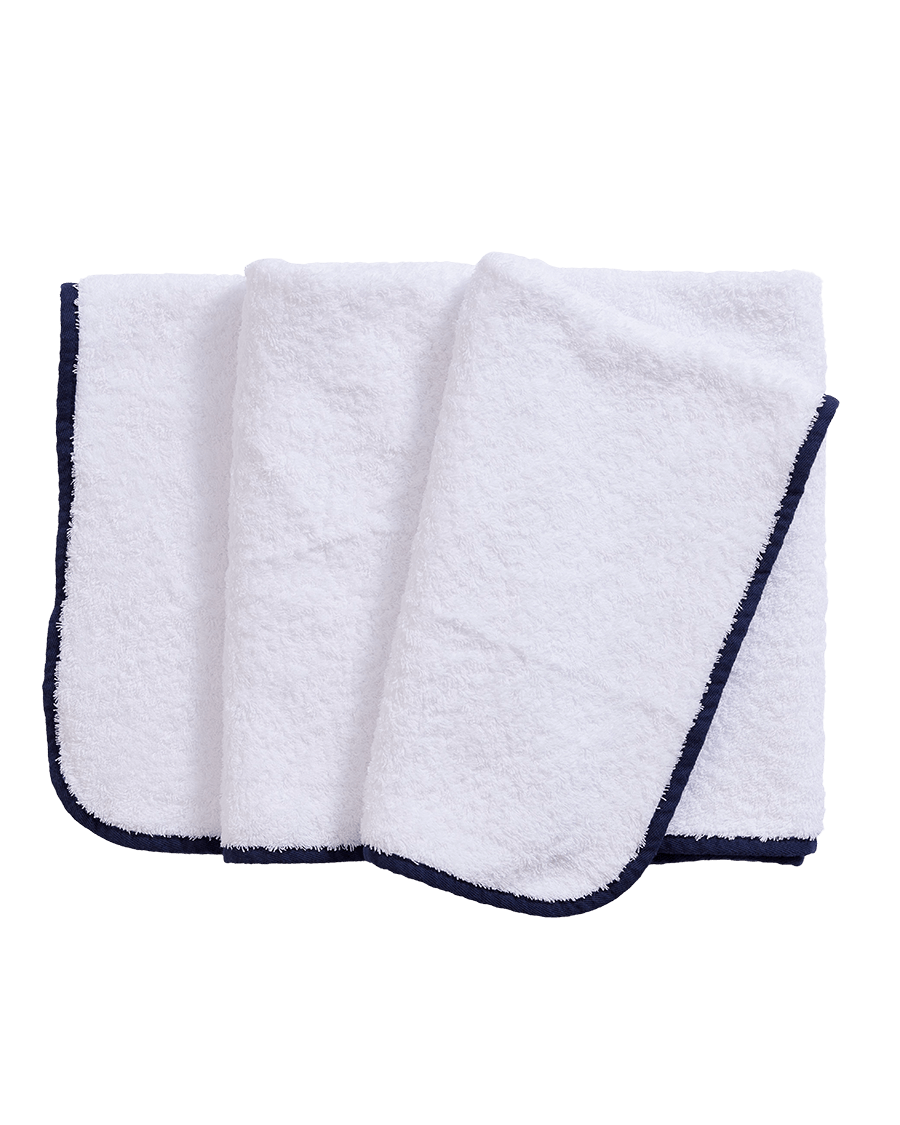 Folded white bath towel with navy bias binding edge.