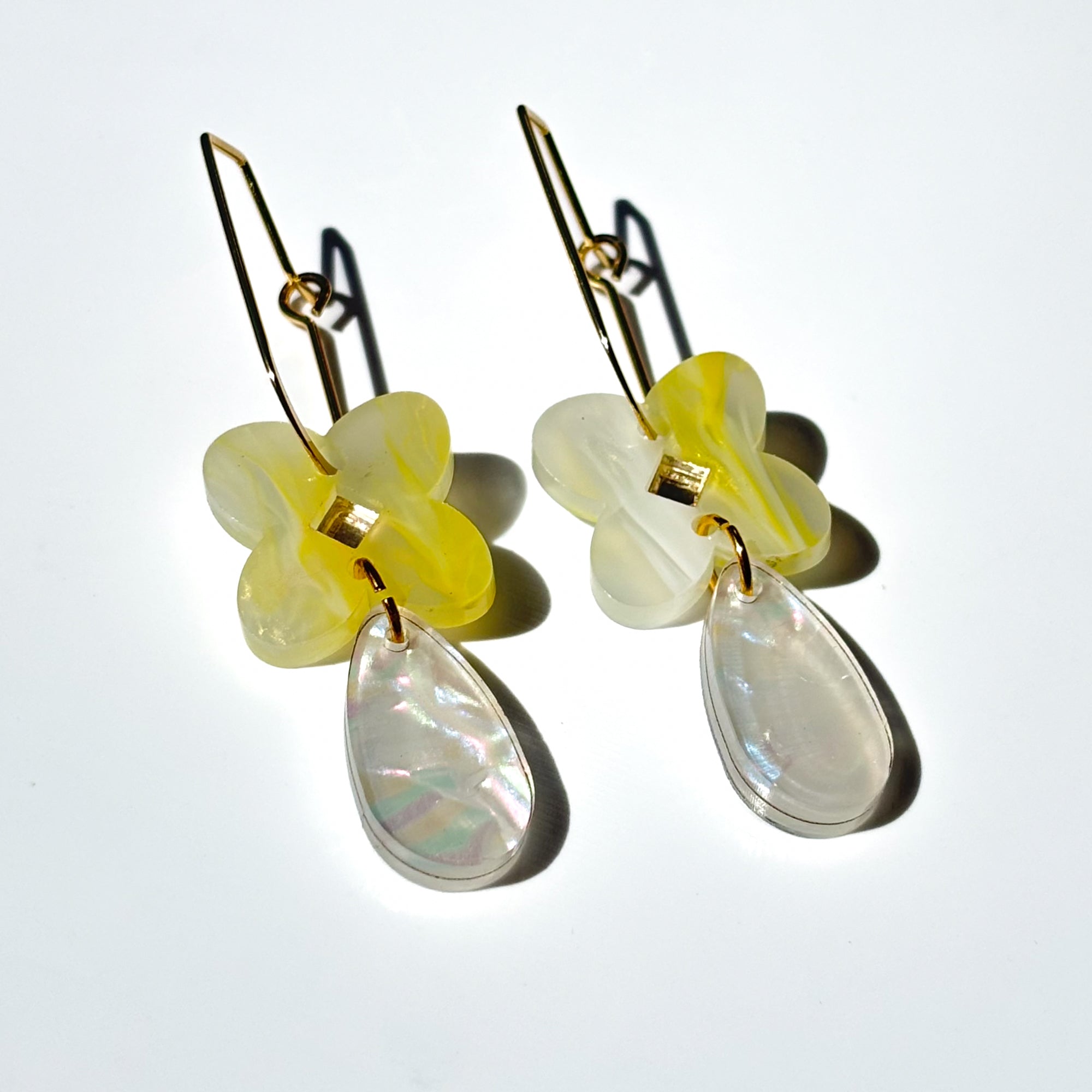 Drop earring in acrylic clover flower in yellow and pearl swirl colour with mirror diamond centre and tear drop attached in pearl.