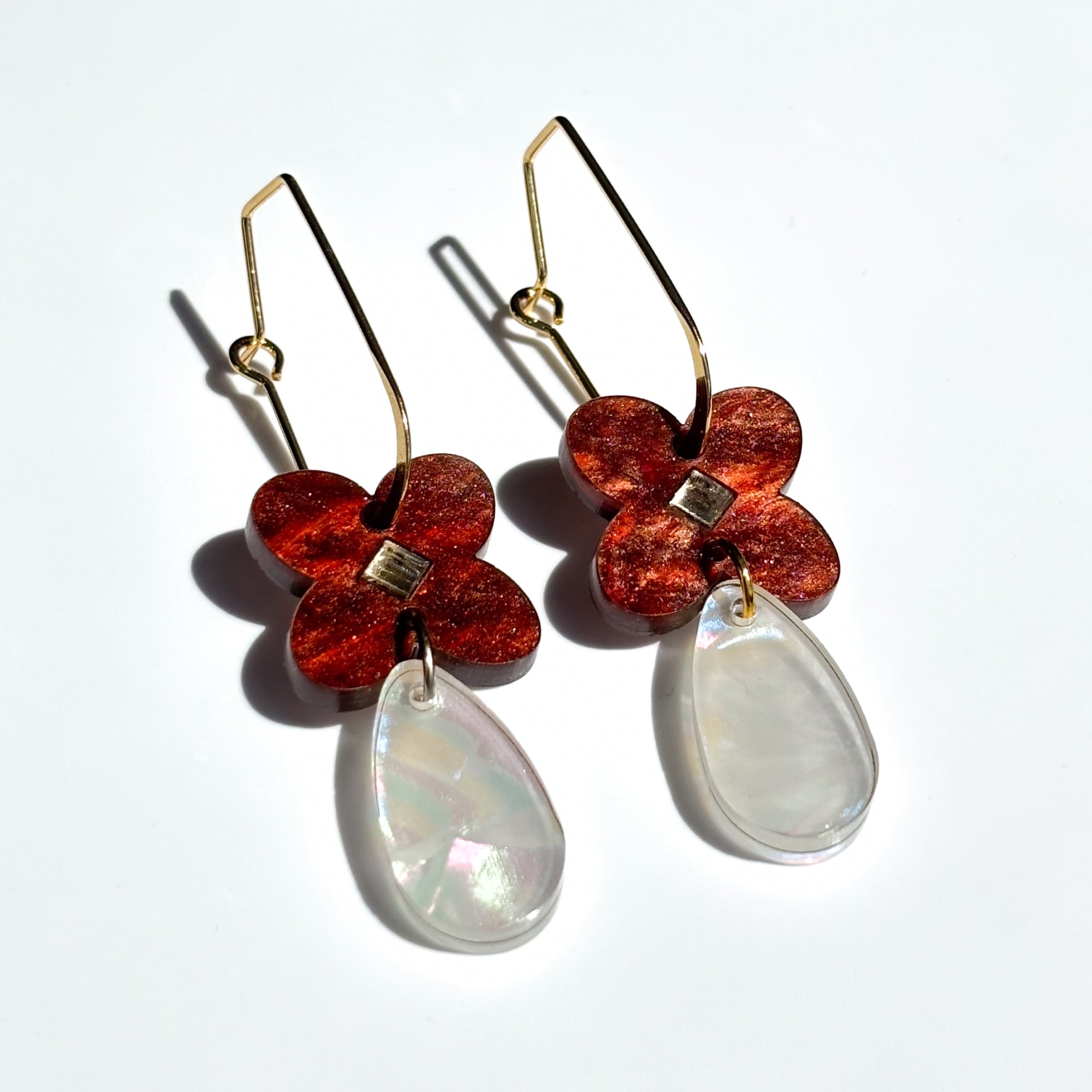 Drop earring in acrylic clover flower in reddish brown swirl colour with mirror diamond centre and tear drop attached in pearl.