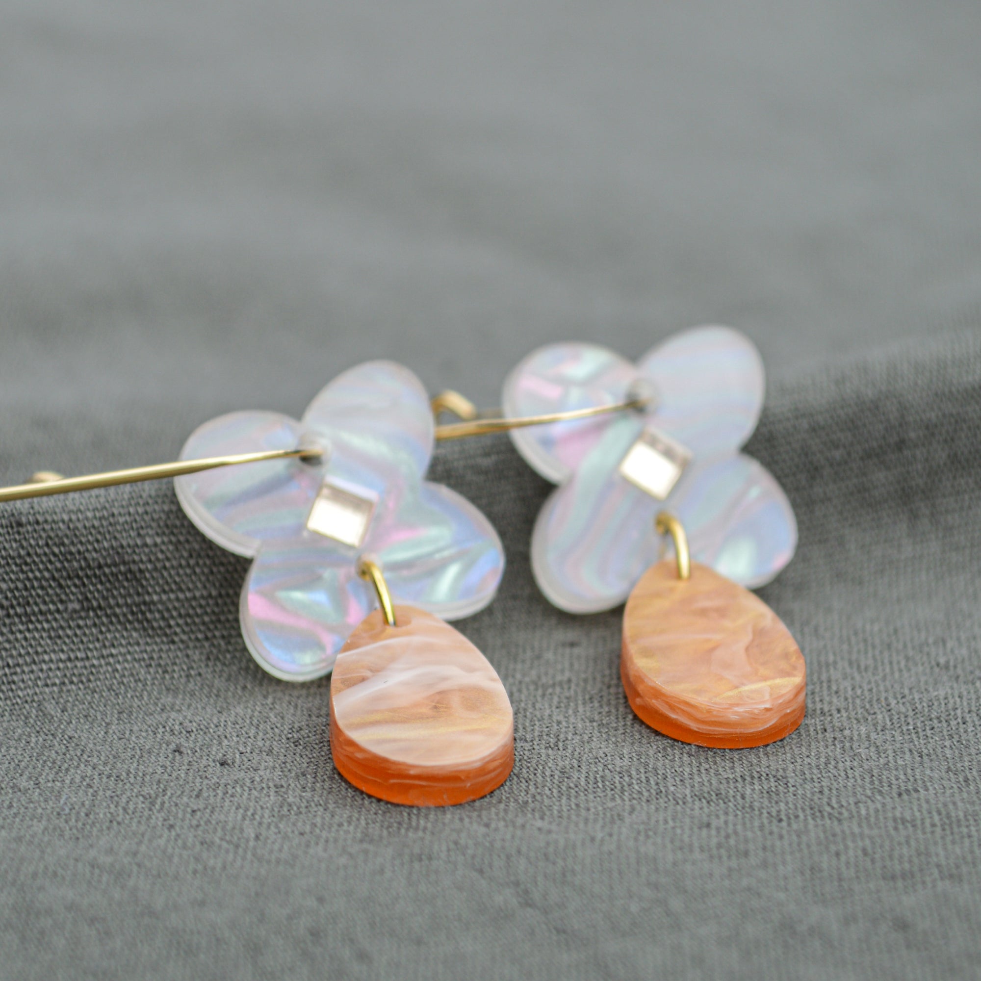 Drop earring in acrylic clover flower in pearl swirl colour with mirror diamond centre and tear drop attached in light brown and pearl swirl colours.