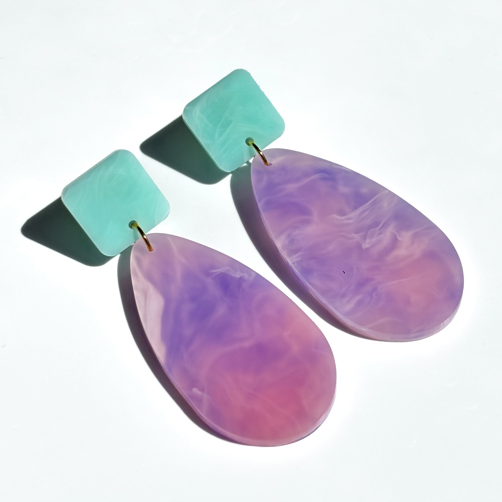 Lavender swirl acrylic dangle earrings in a large tear drop shape with light green colour square shape at the top and attached.