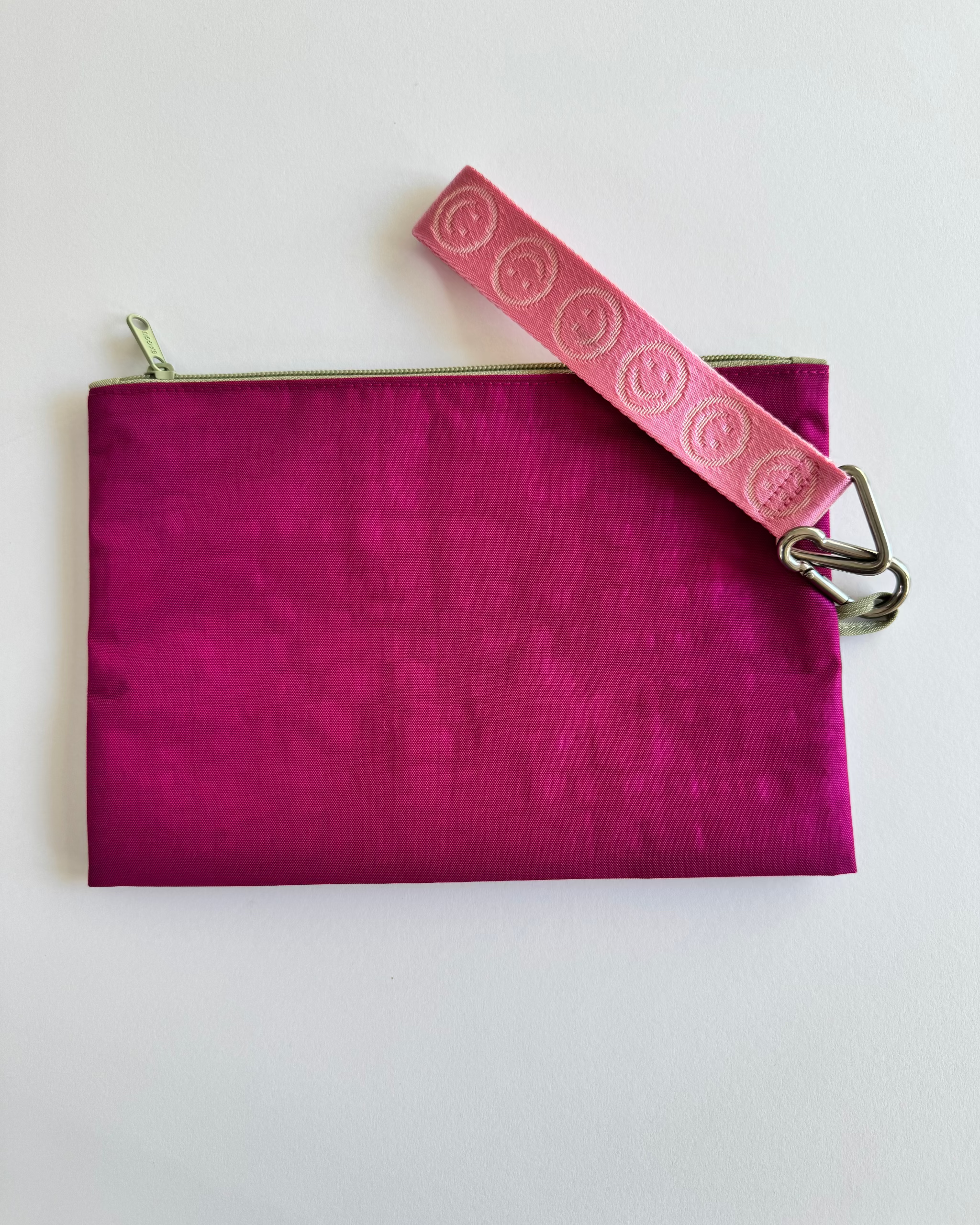 Medium size, fuchsia side of go pouch with pink happy logo keychain attached.