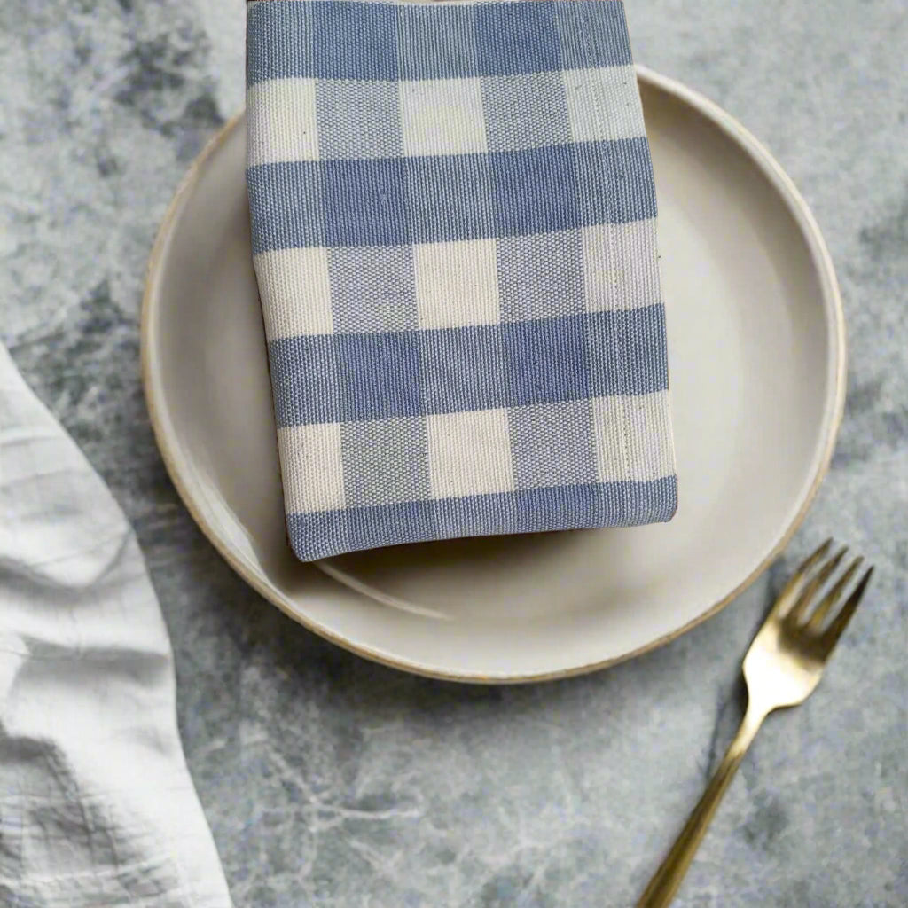 blue-gingham-napkin-on-a-plate-next-to fork-on-bench