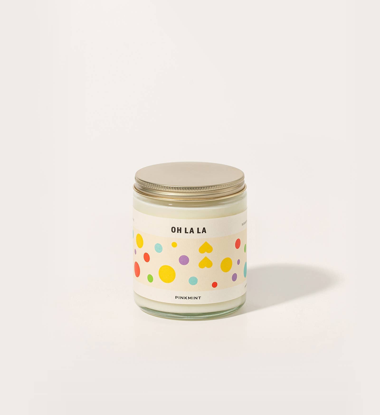 jar with white candle inside and a metal lid and a colourful label - ANNIE.G