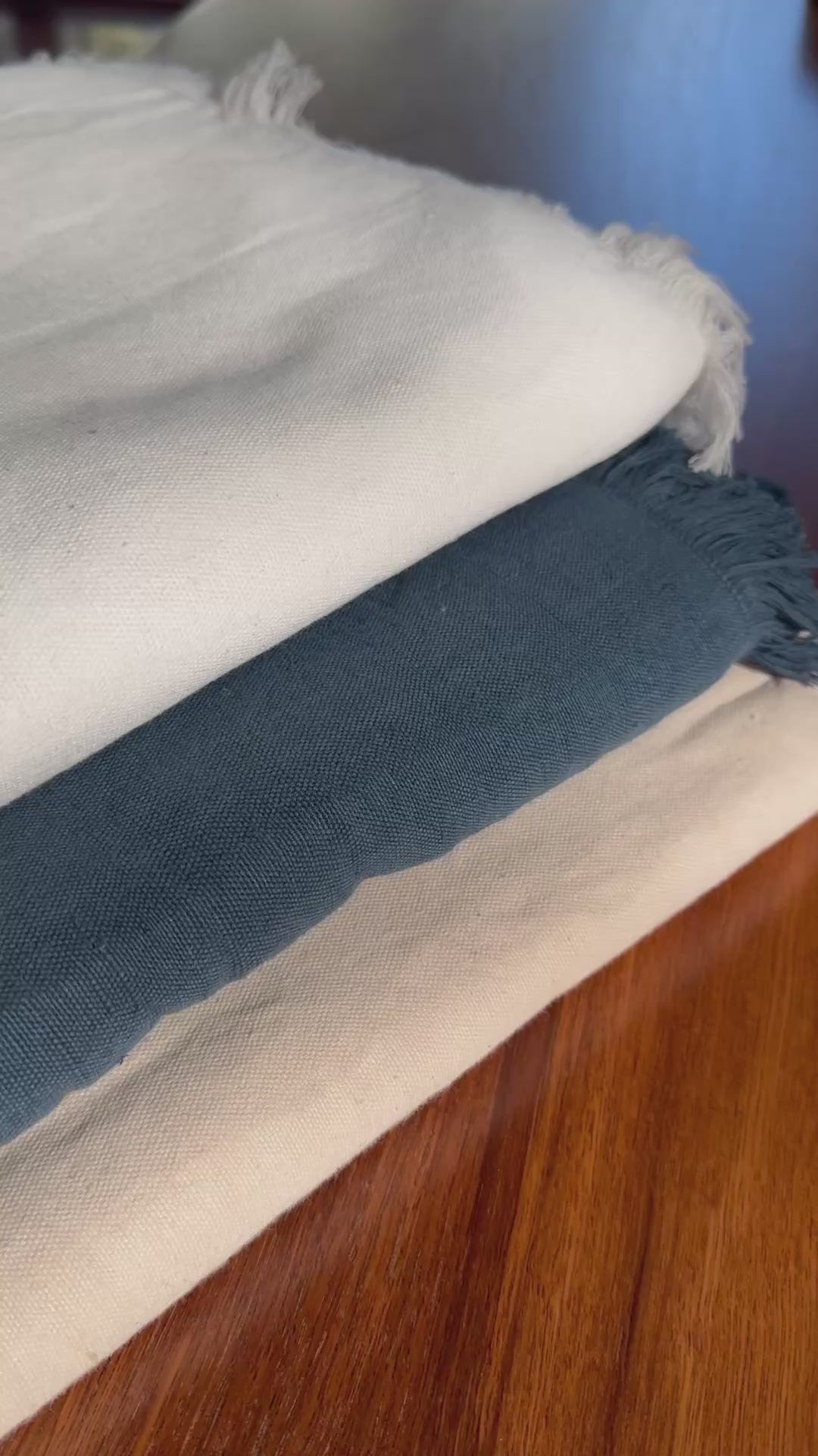 video of tablecloths with a fringe edge in white, ocean blue and blush with white napkins