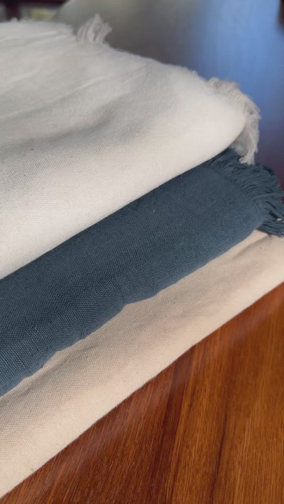 video of tablecloths with a fringe edge in white, ocean blue and blush with white napkins