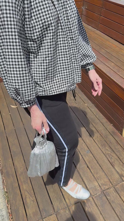 woman showing the inside of the pleated Baggu drawstring pouch and reusable shopping bag.