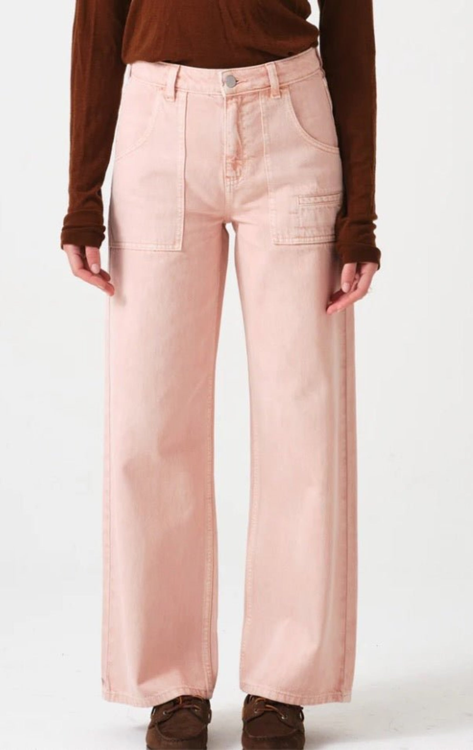 Woman wearing pink jeans and jumper.