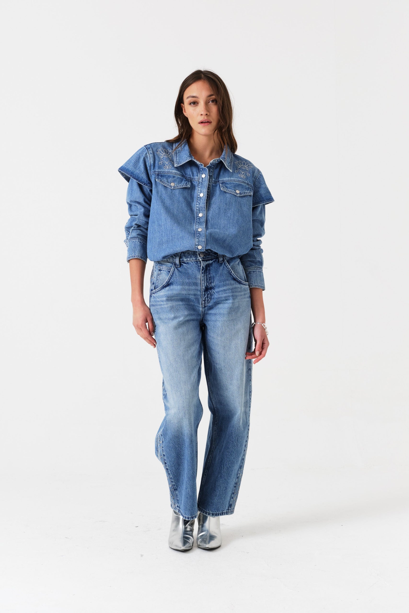 Woman wearing a blue denim shirt and jeans.