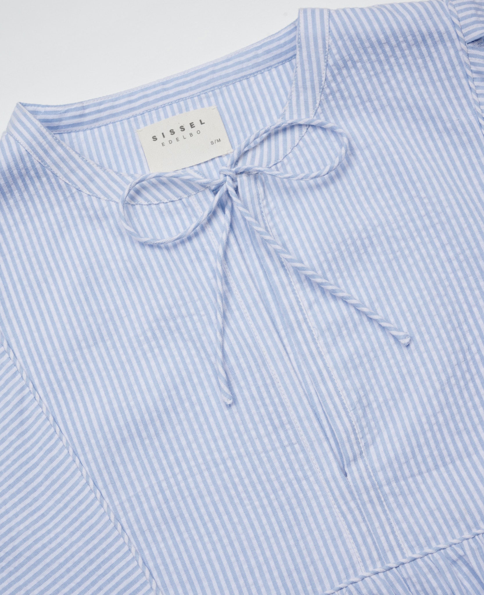 Close up of v-neckline with ties on light blue and white stripe dress - ANNIE.G