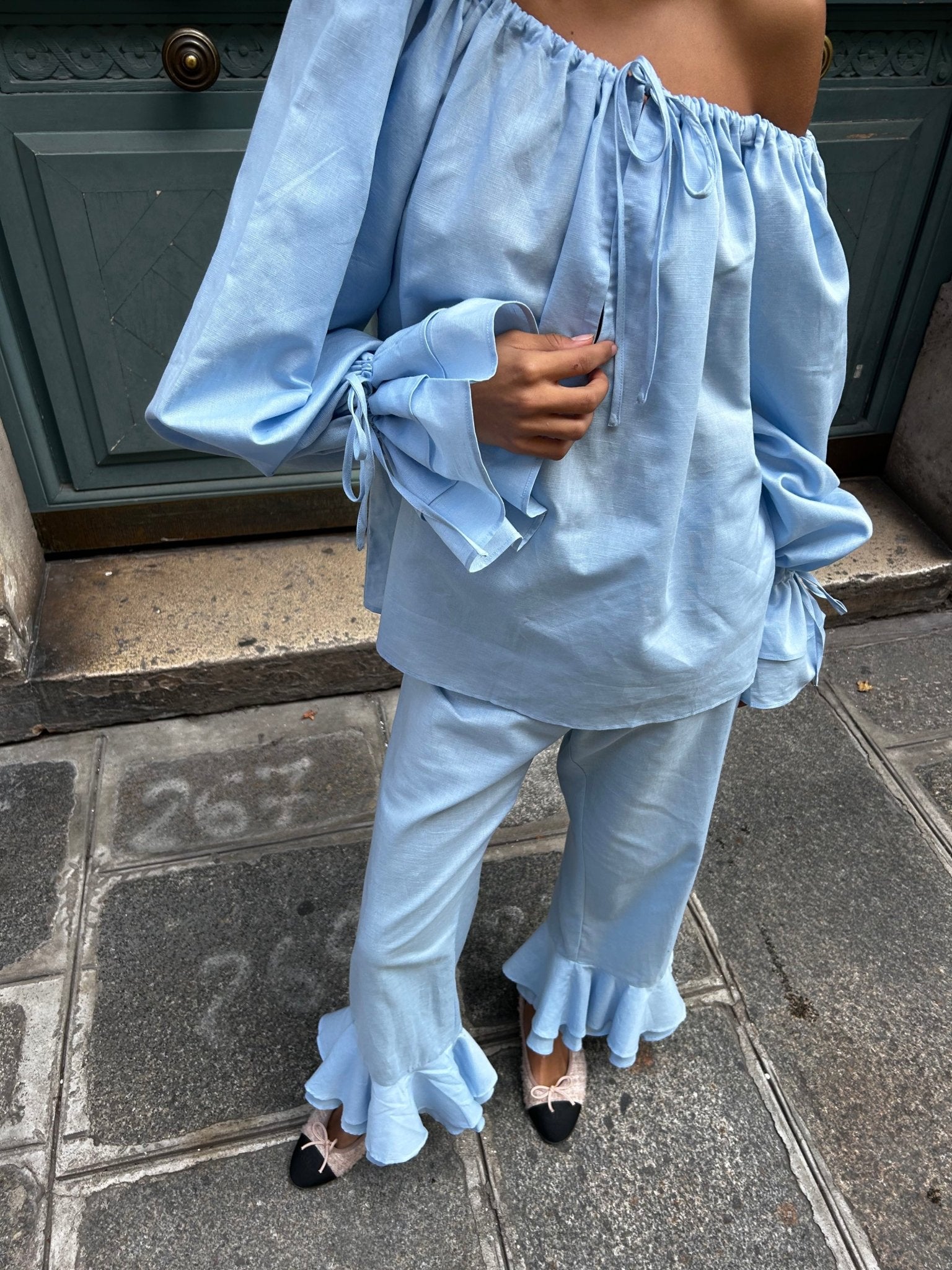 Close up of a women wearing a blue linen off the shoulder top and pants set - ANNIE.G