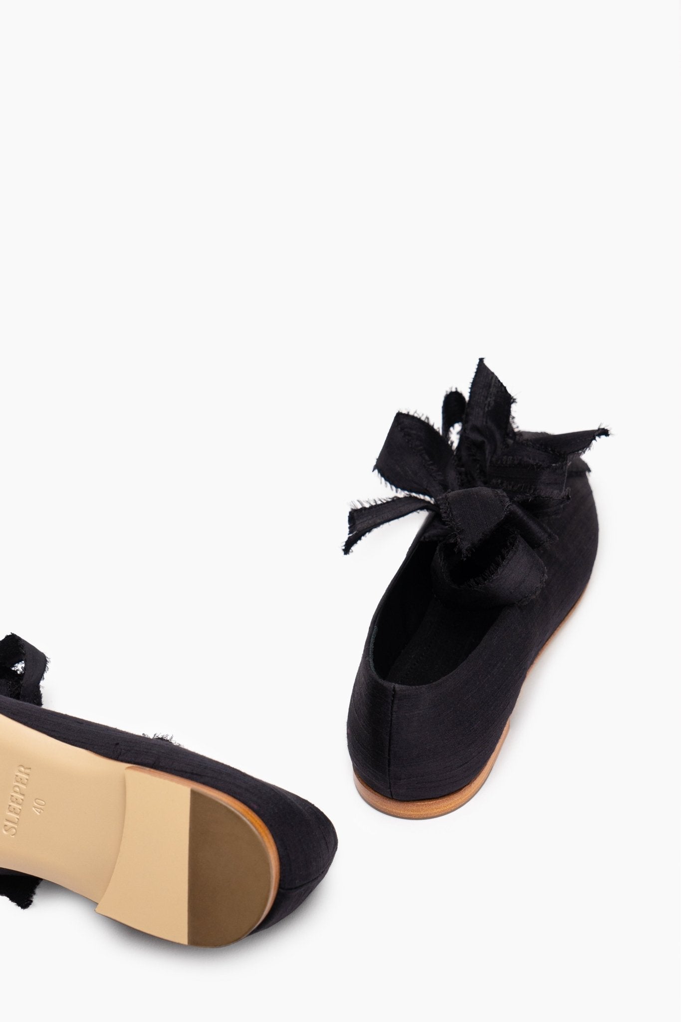 Leather sole and low heel of black silk ballet shoe.