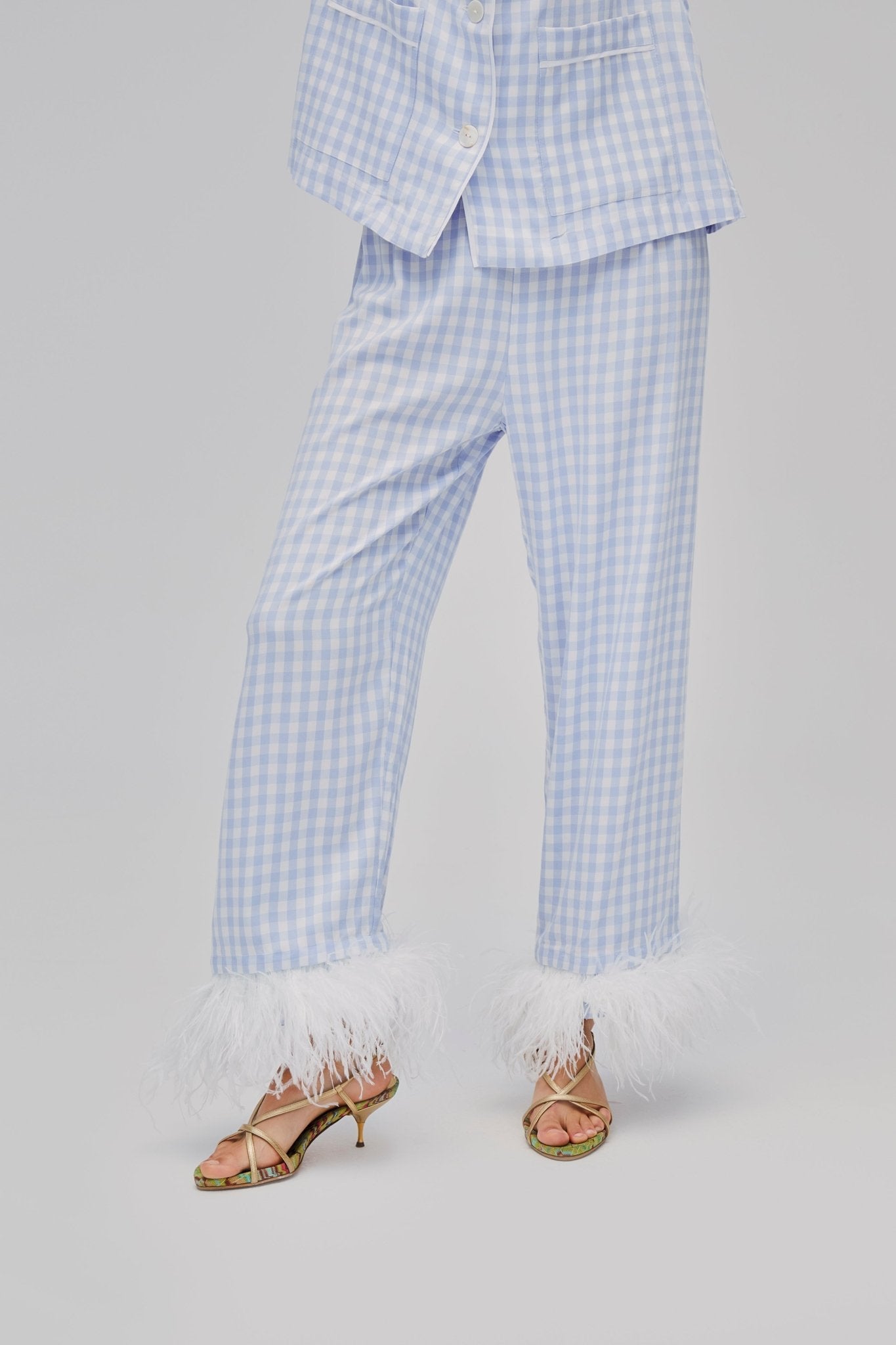 Woman wearing blue vichy long Party Pyjamas pants with white Detachable Feathers on cuff.