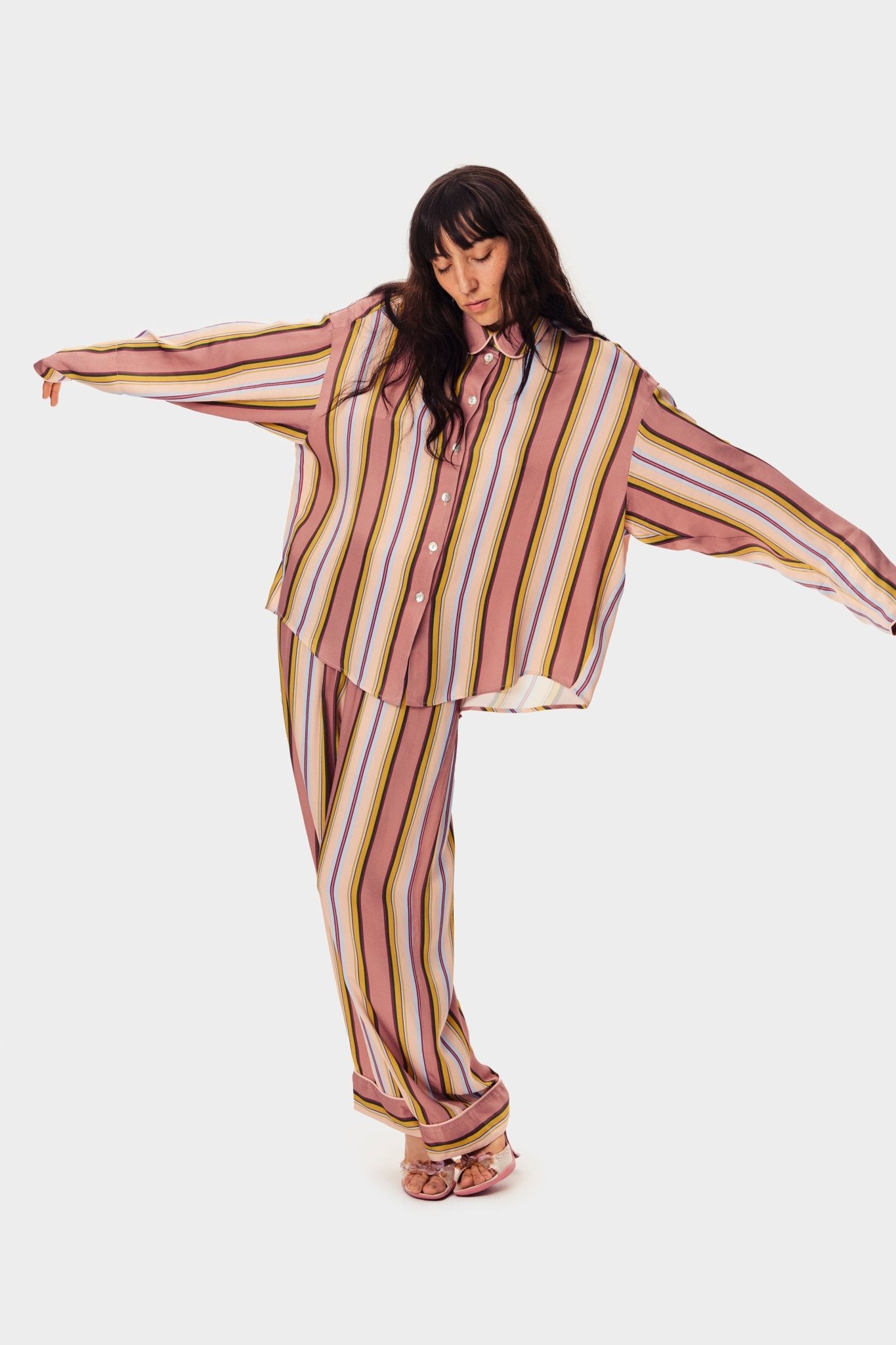 Woman wearing long sleeved pink striped shirt in oversized fit with buttons and collar and matching long pants - ANNIE.G