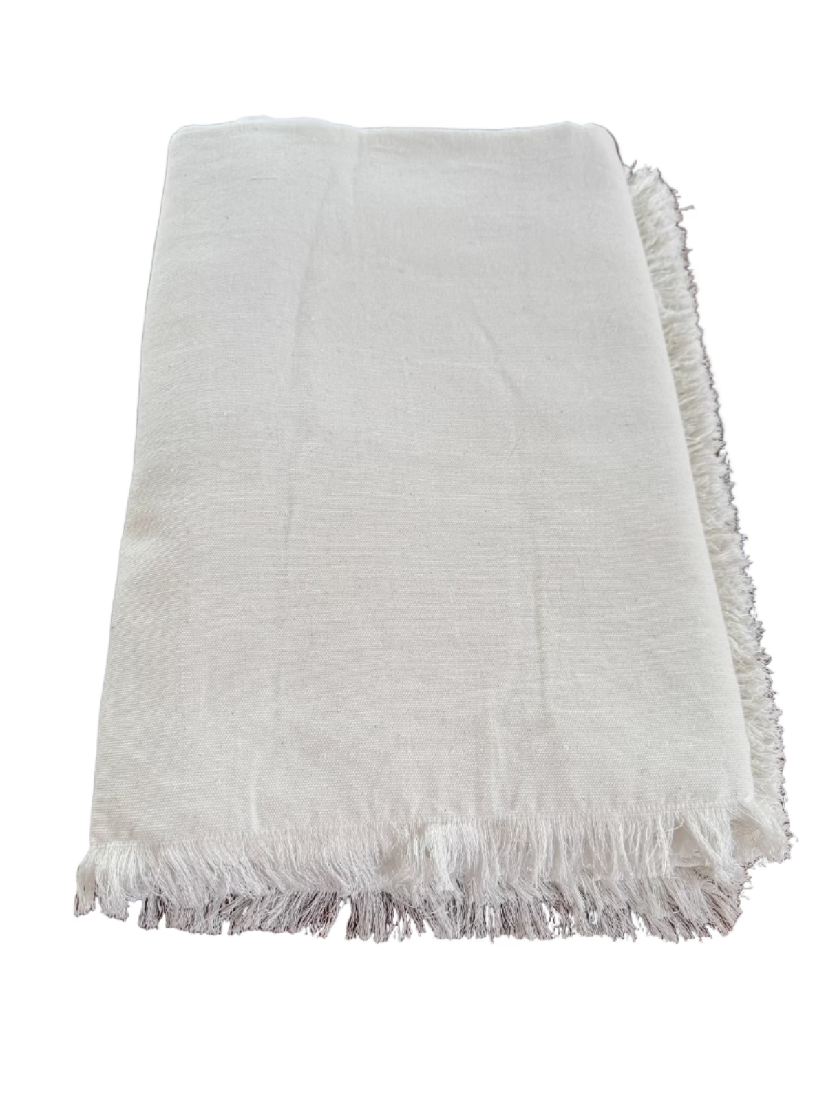 Folded white fringe organic cotton tablecloth on a table